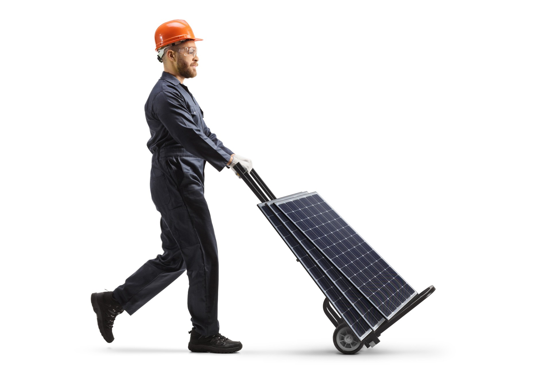 Full length profile shot of a factory worker pushing hand truck with solar panels